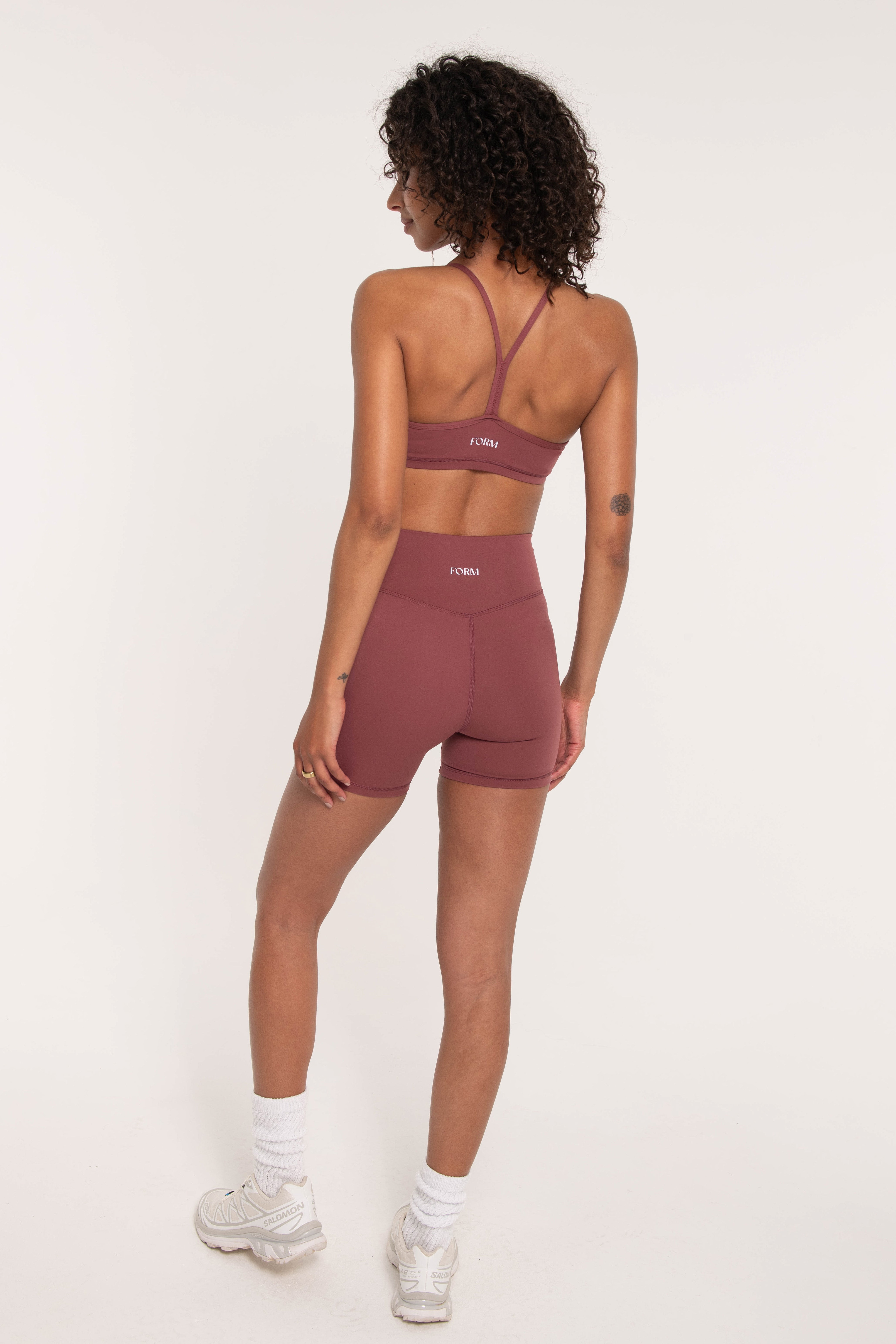 rust pink sports bra from the back with biker shorts